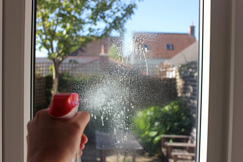 Person spraying a window.