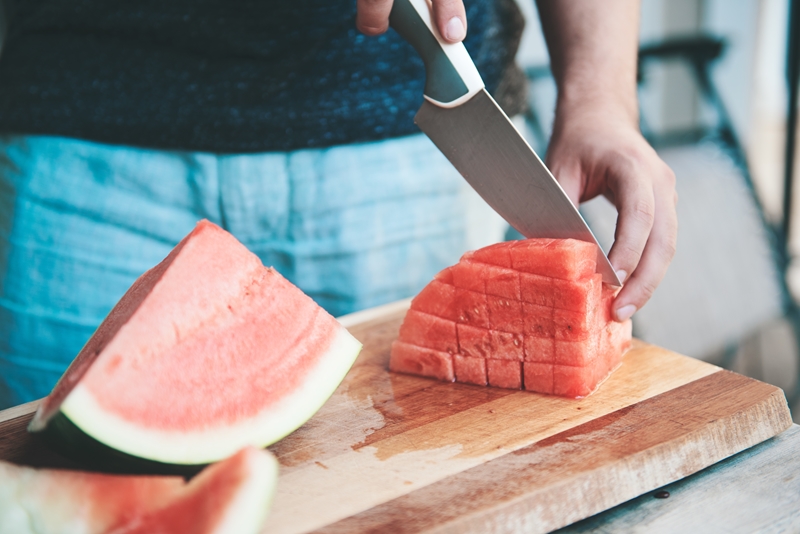 Person cutting a watermelon.